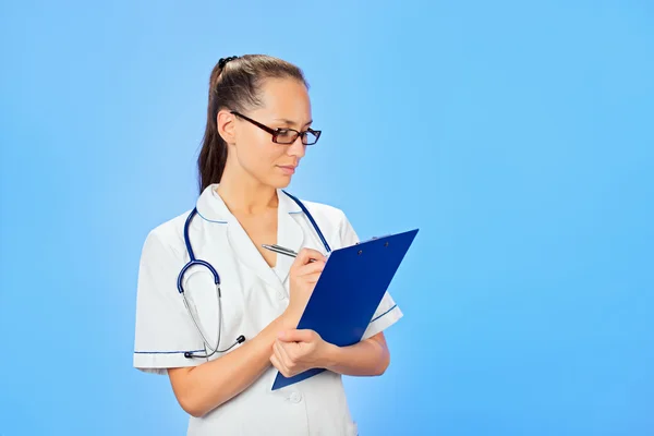 Молодая красивая женщина врач пишет на планшете, талия высотой по — стоковое фото