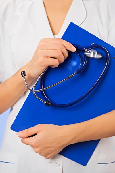 Doutor com copyspaced clipboard cintura-alto retrato em azul — Fotografia de Stock