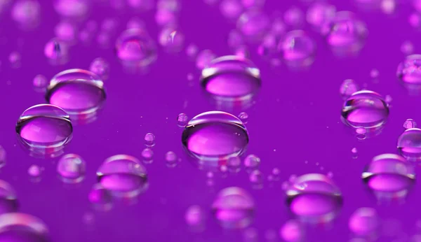 Krople fioletowy streszczenie wody przezroczyste tło, widok makro — Zdjęcie stockowe