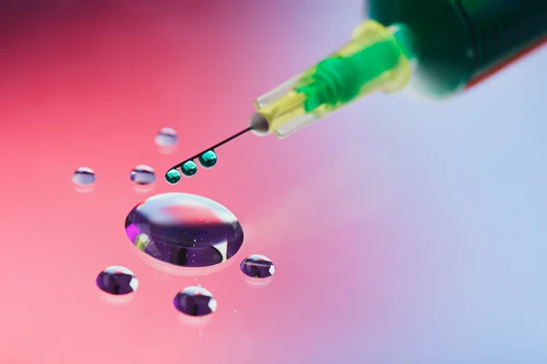 Syringe needle with fluid drops on droplets water background, ma — Stock Photo, Image