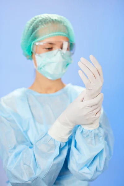 Молодой красивый хирург врач (женщина) перед операцией на синем — стоковое фото