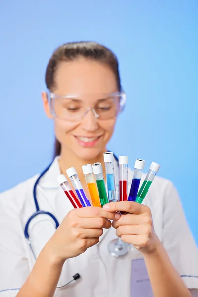 Tubos de ensayo médicos con primer plano de la muestra de líquido en la mano del médico en b — Foto de Stock