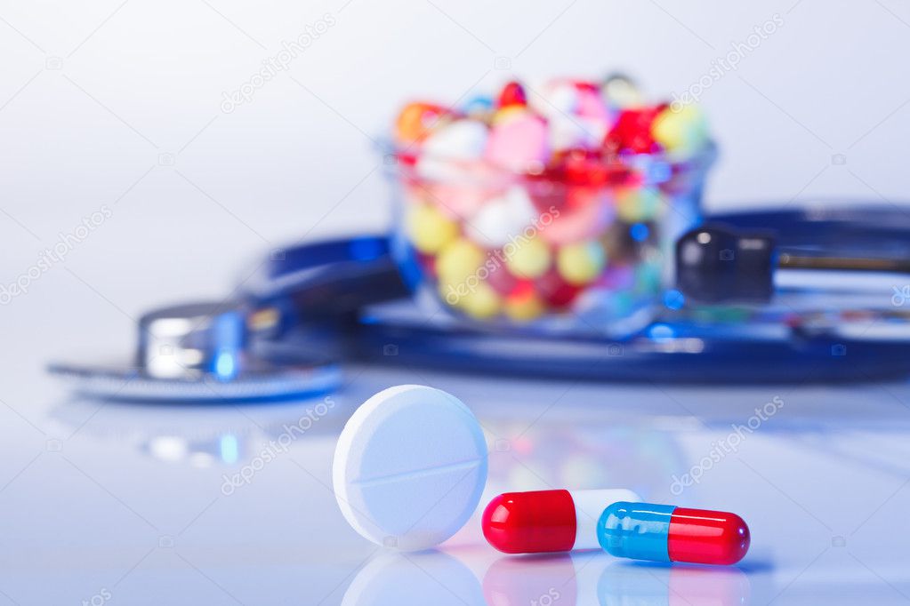 Pills and tablets macro still life on white blue, medical therap