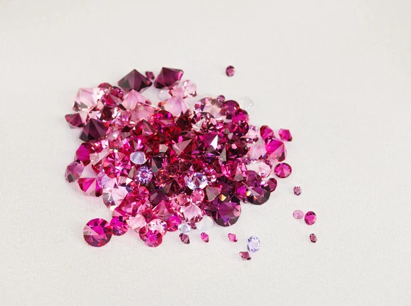 Diamante (rubino) pietre mucchio su sfondo tessuto di seta crema — Foto Stock
