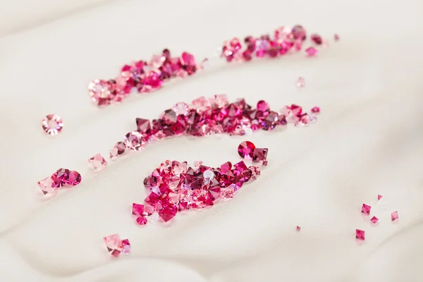 Diamante (rubi) pedras heap sobre creme pano de seda fundo — Fotografia de Stock