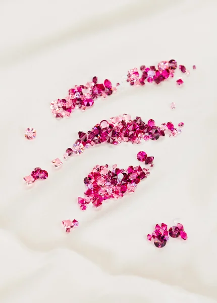 Piedras de diamante (rubí) amontonadas sobre fondo de tela de seda crema — Foto de Stock
