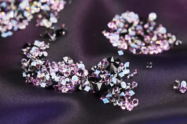 Diamant (kleiner lila Juwel) Steine häufen sich über schwarzem Seidentuch — Stockfoto