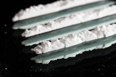 Cocaine drugs lines still life on a dark mirror, close up view clipart