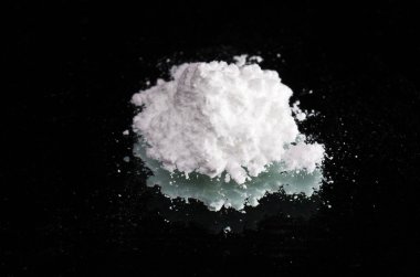 Cocaine drugs heap on a black mirror, close up view clipart