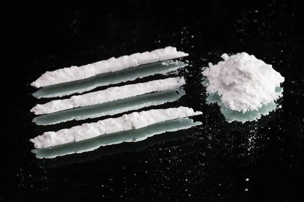 Kokainy narkotyków sterty i linie wciąż życie na ciemnym lustrem, blisko — Zdjęcie stockowe