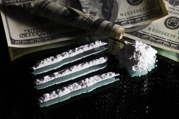 Kábítószerek kokain kupacban csendélet egy tükör a hengerelt 100 dollár — Stock Fotó