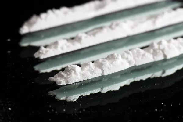 Close-up van drugs cocaïne stilleven lijnen op een donkere spiegel, — Stockfoto