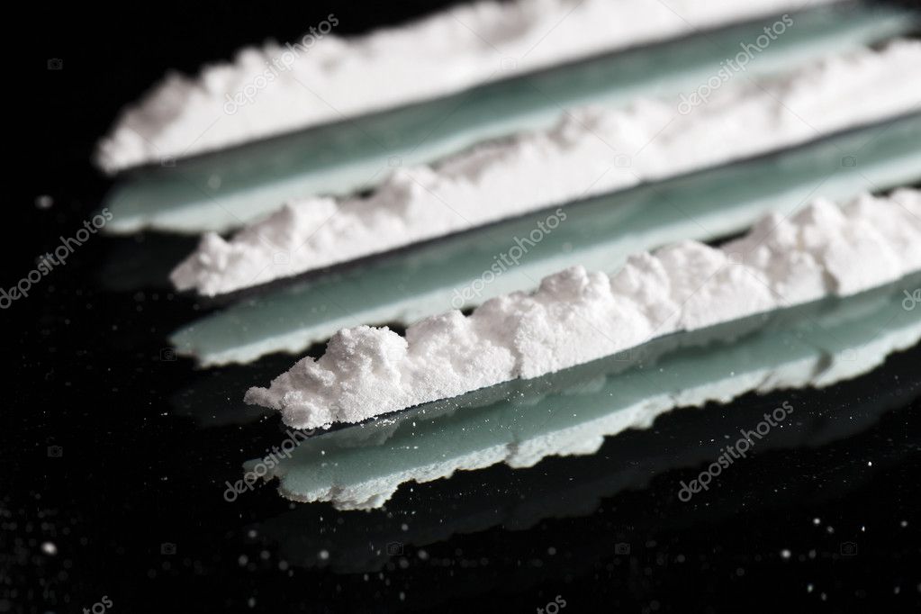 Cocaine drugs lines still life on a dark mirror, close up view