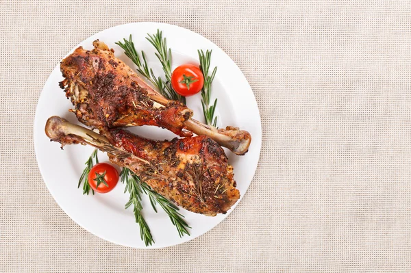 stock image Roasted turkey legs on white plate with cherry tomato and rosema