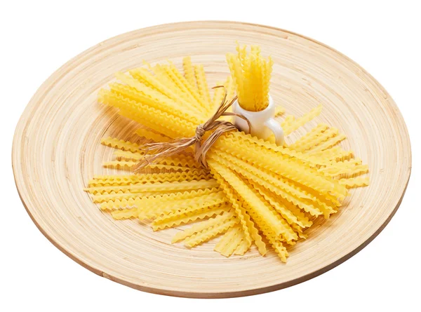 Composizione a grappolo di pasta su un piatto di legno, isolato su bianco — Foto Stock