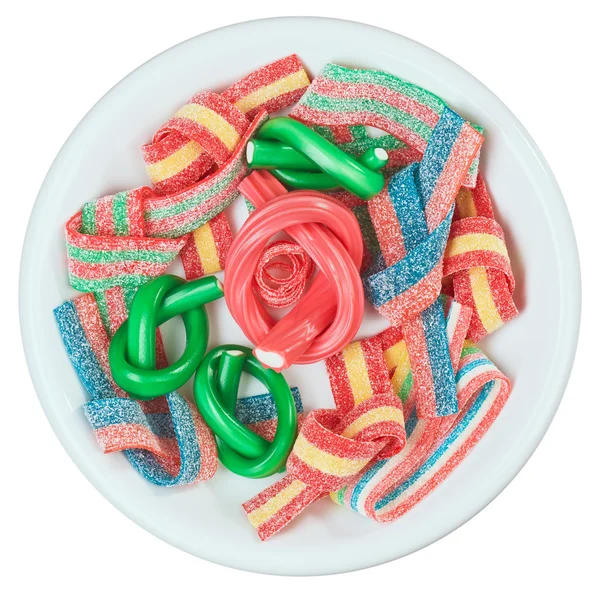 Doces de goma colorida (alcaçuz) em um prato branco, isolar — Fotografia de Stock