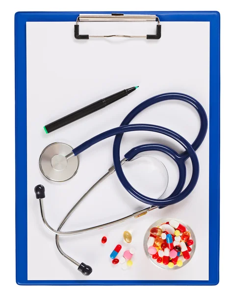 与听诊器和丸上 wh 孤立的蓝色医疗剪贴板 — 图库照片