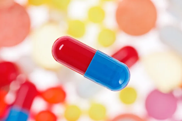 Bir kapsül (hap) makroyu görüntüleme bulanık çok renkli uyuşturucu geri — Stok fotoğraf