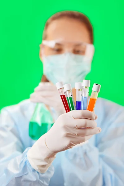 Tubos de ensayo médicos con muestra de líquido en la mano del médico en verde b —  Fotos de Stock