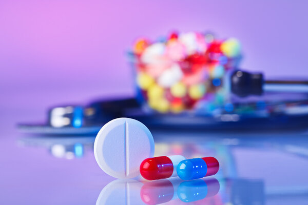 Pills and tablets macro still life on violet, medical therapeuti