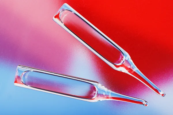 Medizinische Ampullen auf rotem und blauem Hintergrund mit lebhafter Farbe — Stockfoto