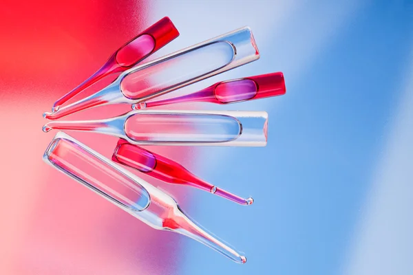 Orvosi ampullákat, a piros és a kék élénk színű háttér — Stock Fotó