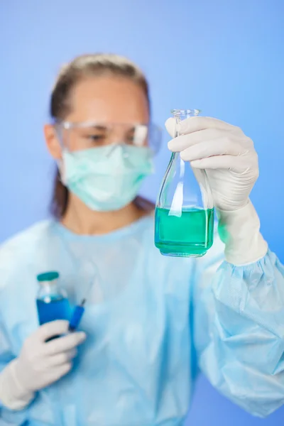 Zkumavky lékařské vzorky v rukou lékaře na modrém pozadí — Stock fotografie