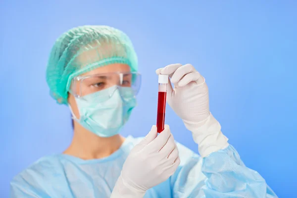 Probówki medyczne próbek w ręce lekarza na niebieskim tle — Zdjęcie stockowe