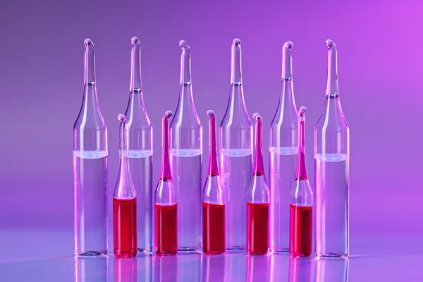 Ampules arranged in a line in vivid violet colors — Stock Photo, Image