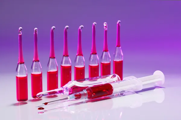 Red Ampoules and syringe still life in vivid colors — Stock Photo, Image