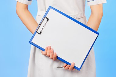 Doctor with copyspaced clipboard waist-high portrait on blue clipart