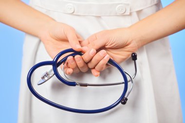 Doctor holding stethoscope behind her back, waist-high portrait clipart