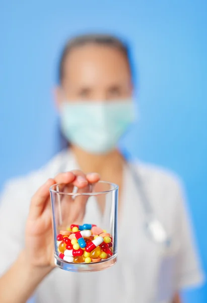 青い背景に医師の手の丸薬、錠剤や薬のヒープ — ストック写真