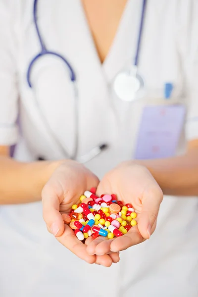 Pills, tablets and drugs heap in doctor's hand on blue backgroun — Stock Photo, Image