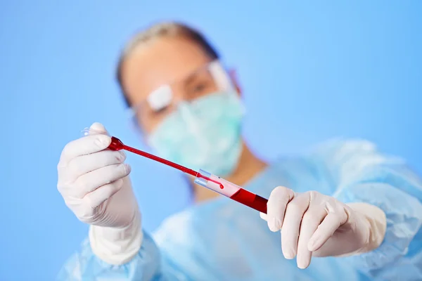 Jovem médico fazendo análise de sangue com tubo de teste e gota — Fotografia de Stock