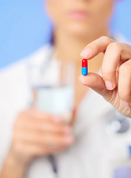 Bolo rojo y azul (cápsula) en la mano del médico, vista de cerca —  Fotos de Stock
