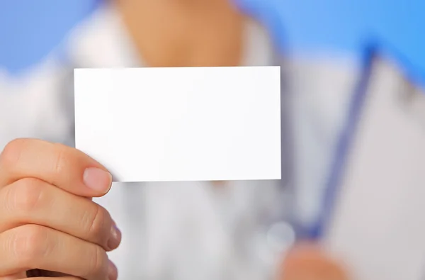Médico (mujer) sosteniendo tarjeta de visita en blanco con espacio de copia en bl Fotos de stock