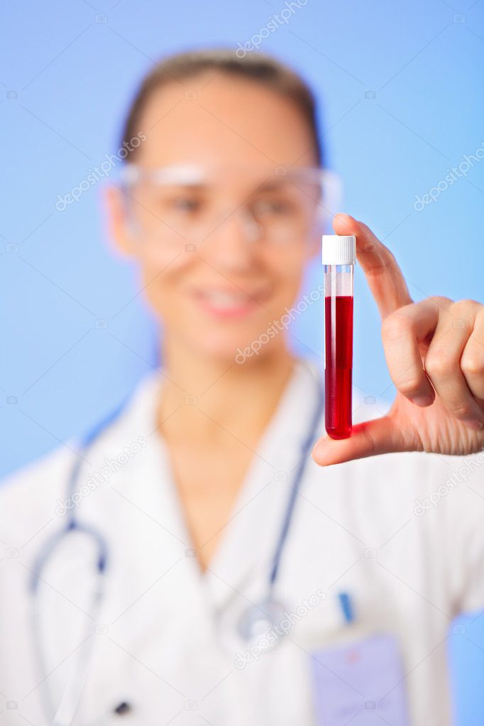 Test tube with blood sample in doctor hand on blue background
