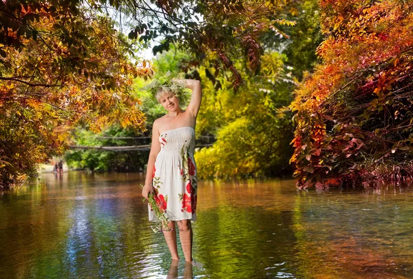 The girl with a bunch of flowers, standing in the river — Stock Photo, Image