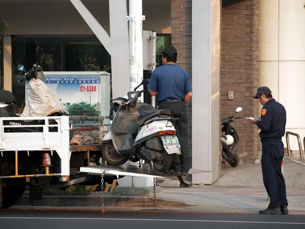 Polis yasadışı park edilmiş scooter işaretini kaldırın. — Stok fotoğraf
