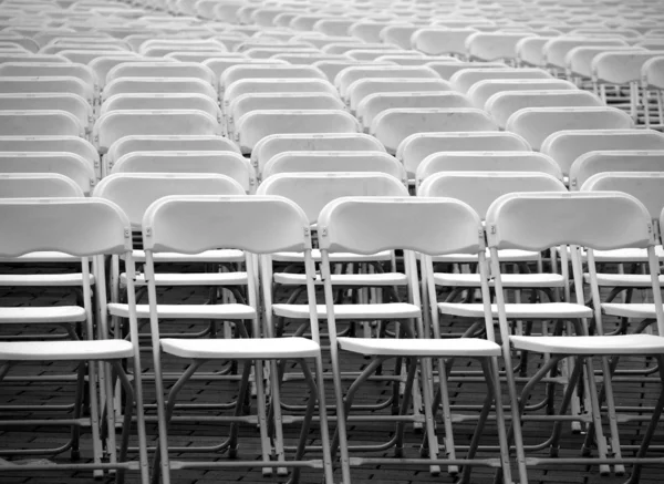 Een veelheid van witte plastic stoelen — Stockfoto