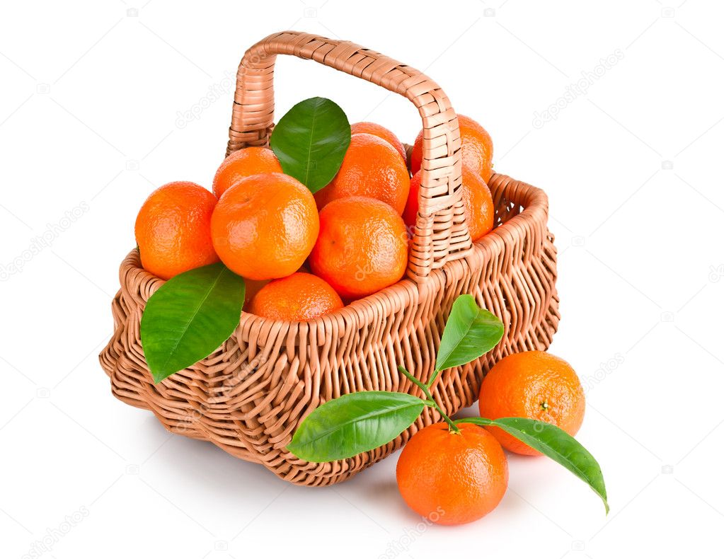 Ripe tangerines with leaves in basket