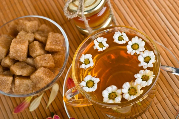 Tisana con camomilla in tazza di vetro e zucchero di canna — Foto Stock