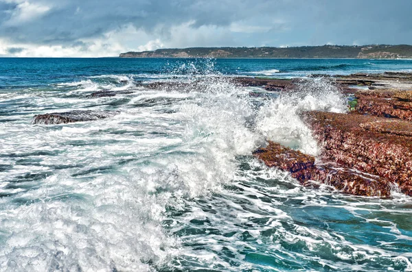 Vågor på klipporna vid kusten — Stockfoto