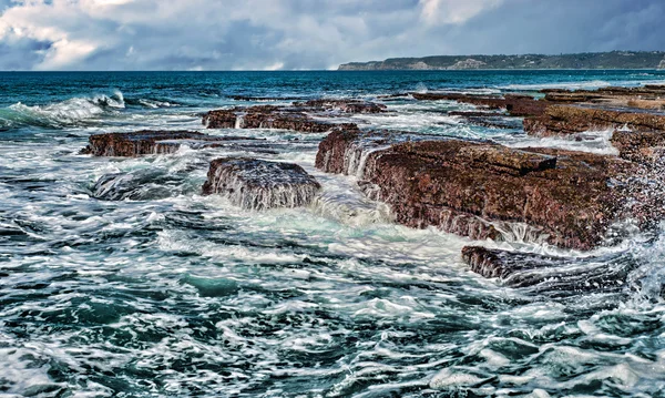 Wellen auf Felsen an der Küste — Stockfoto