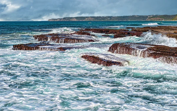 Wellen auf Felsen an der Küste — Stockfoto