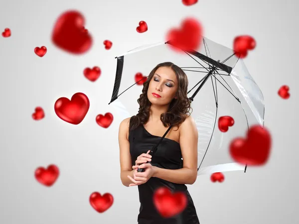 Mujer joven y bonita con paraguas y corazones —  Fotos de Stock