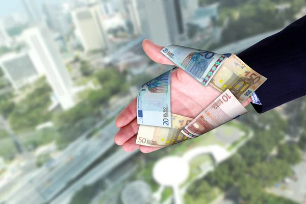 Міський пейзаж і руки, що тримають банкноти — стокове фото