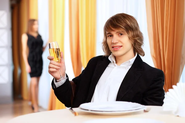 Junger schöner Mann sitzt im Restaurant — Stockfoto