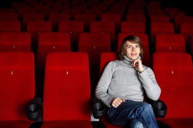 Young man in cinema watching movie clipart